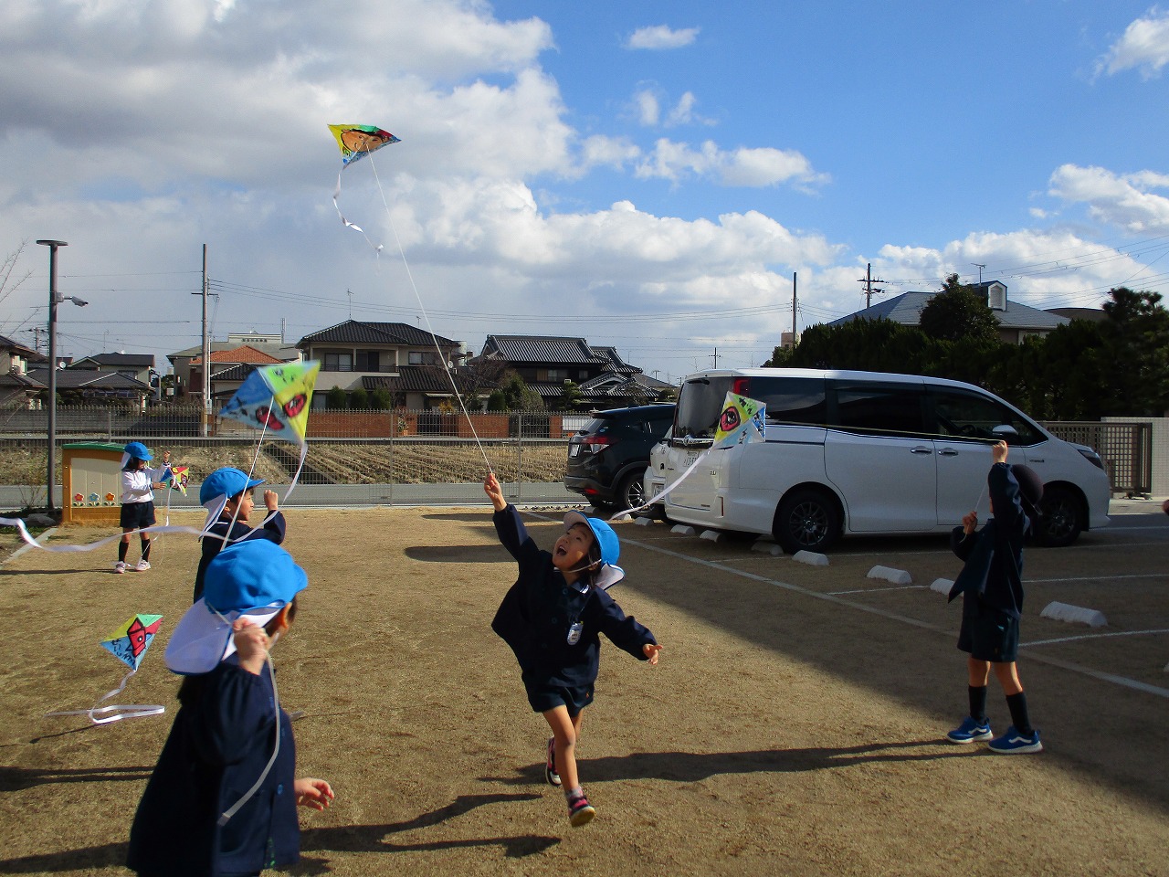 男の子が走って凧揚げをしています